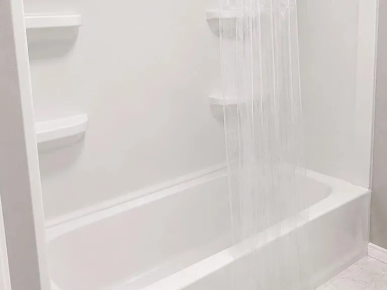 Tub/shower combo with built-in shelving and an overhead rainfall showerhead for everyday convenience.