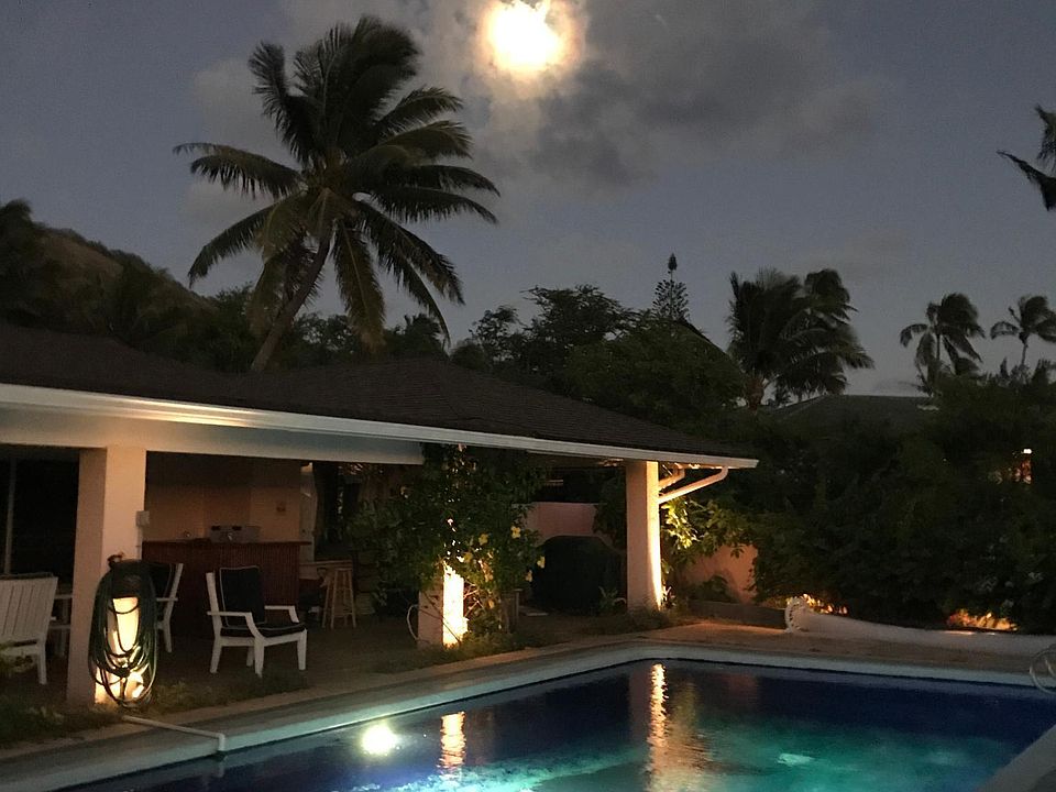 Full moon rising over lighted pool.