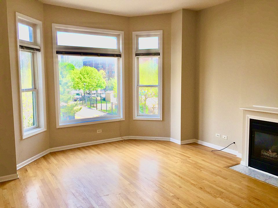 Living room with Bay Window, fireplace, hard-wood floors. Open to the Kitchen