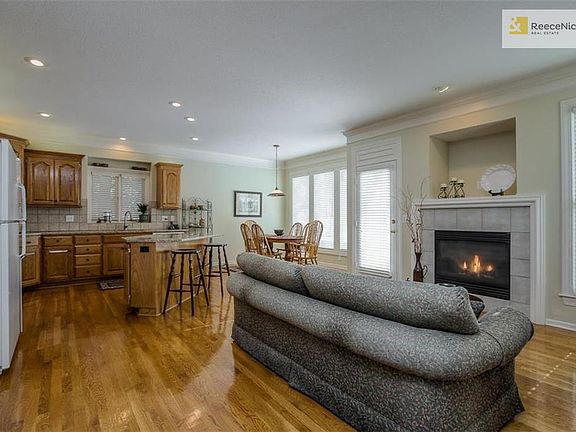 Cozy hearth area off kitchen with hardwood floors and fireplace.