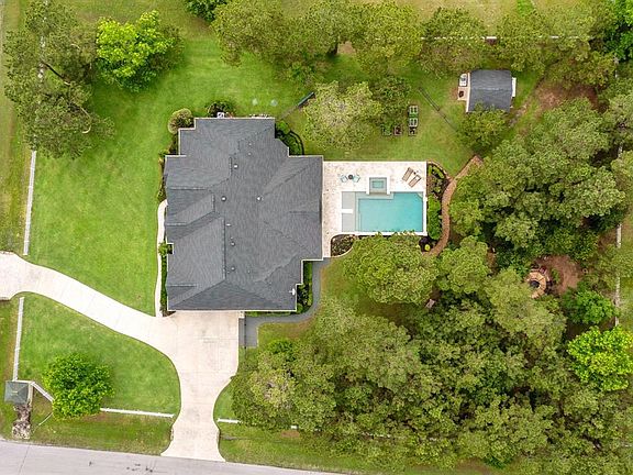 Aerial view of property that shows circle driveway, pool/spa, storage shed & fire pit