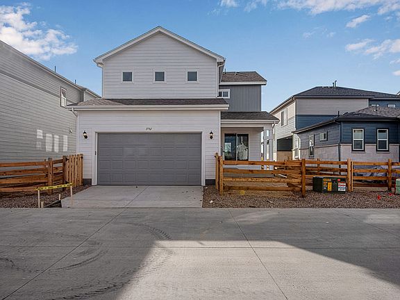 Rear exterior with 2 bay garage, covered patio and side yard