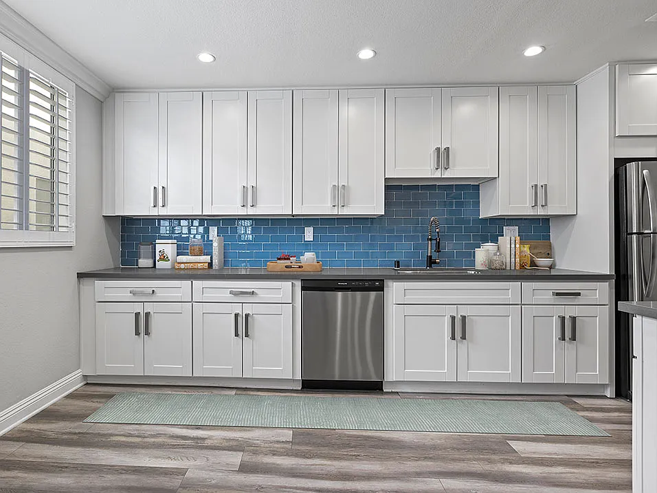 Blue tiled kitchen with stainless steel dishwasher and fixtures.