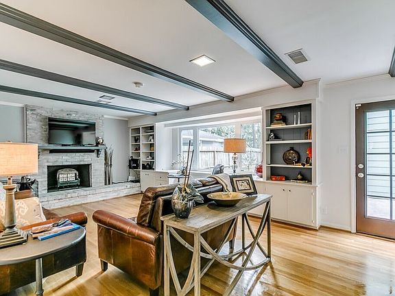 Living room has hardwood flooring, bookshelves that flank a