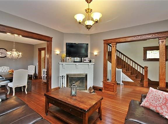 The large living room is accented with wood pillars and brick wood burning fireplace.