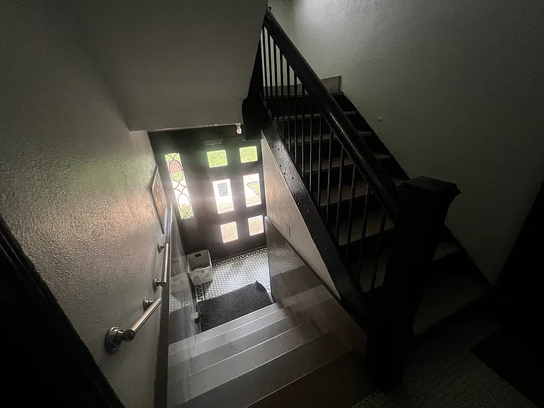 Apartment is on third floor. View coming down the stairs toward front exterior door.