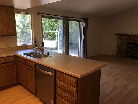 Kitchen facing family room with fireplace 
and slider onto private patio