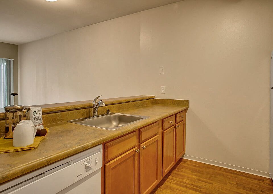 A deep stainless steel sink with lots of surrounding counterspace and a breakfast bar