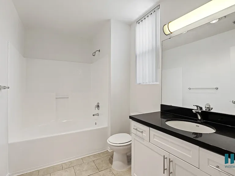 Bathroom with Full-Size Bathtub, Vanity Cabinet Storage, and Window