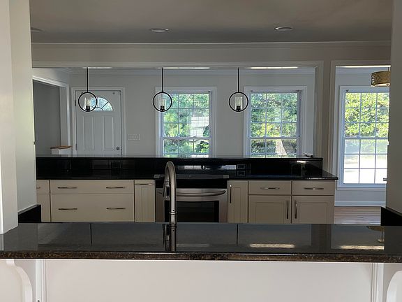 Another view of the front room, seeing into the kitchen. Granite countertop ledge for storage, decor, or as a pass-through area.