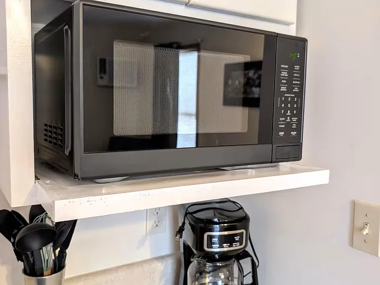 Kitchen counter area with dedicated space for small appliances, including a microwave and coffee maker for quick meals.