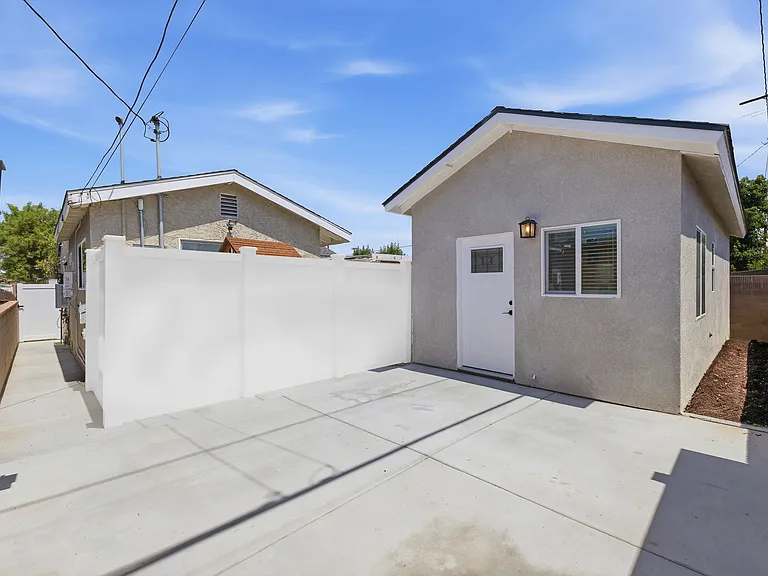 *DIGITALLY ALTERED PHOTO*- (White vinyl fence is in process of being installed). Photo was altered with a vinyl fence to showcase private entrance and patio