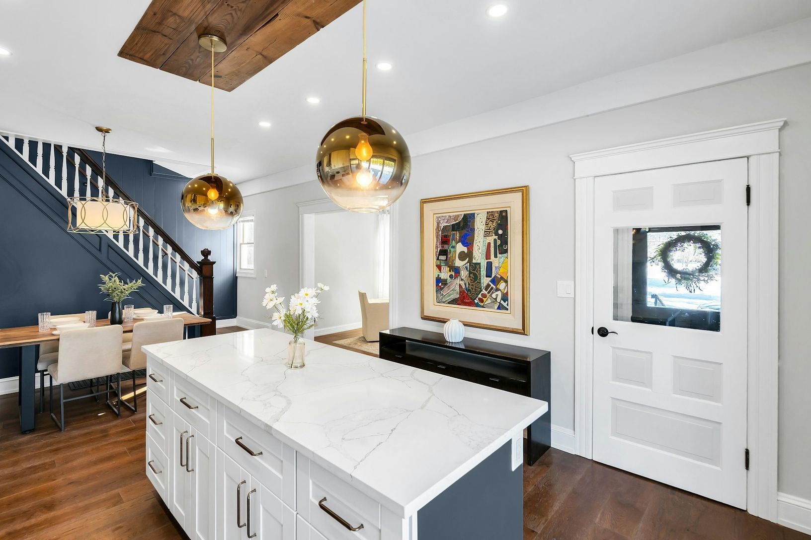  White shaker cabinets with gold and brass finishes. Large kitchen center island.
