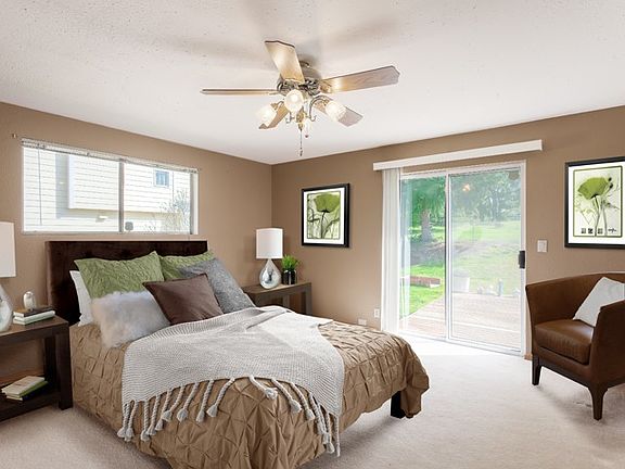 Master suite with sliding glass door to large deck and blossoming backyard features two closets and ceiling fan.
