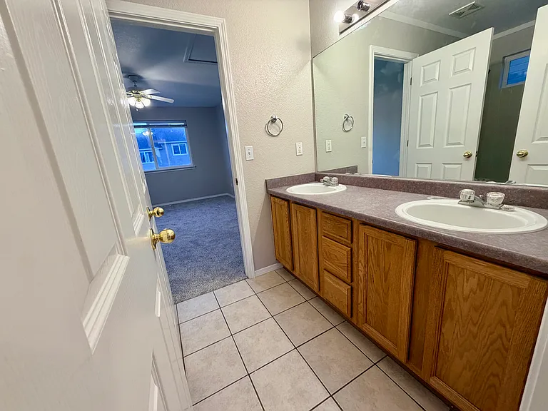Well-designed Jack-and-Jill bathroom featuring a dual-sink vanity with extended countertop space, separate tub/shower and toilet area, and convenient access from both upstairs bedrooms, providing privacy and functionality for everyday use.
