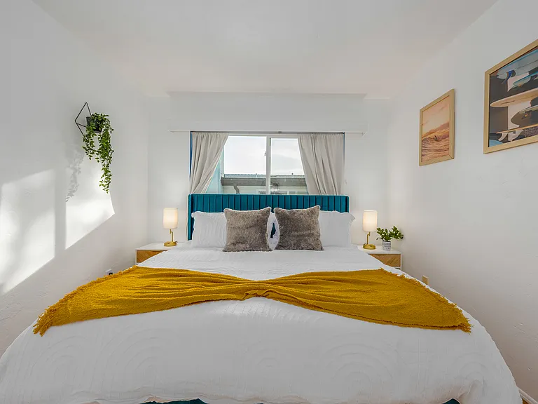 A tranquil, well-lit environment perfect for unwinding.
Serene and stylish bedroom invites guests to unwind in comfort and elegance, featuring a plush king-sized bed adorned with crisp white linens.