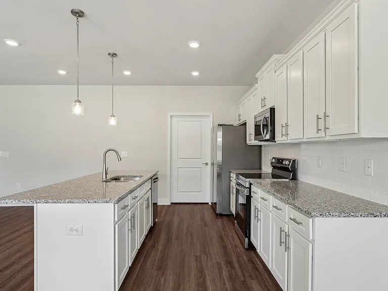 Modern kitchen featuring white cabinets and granite countertops.