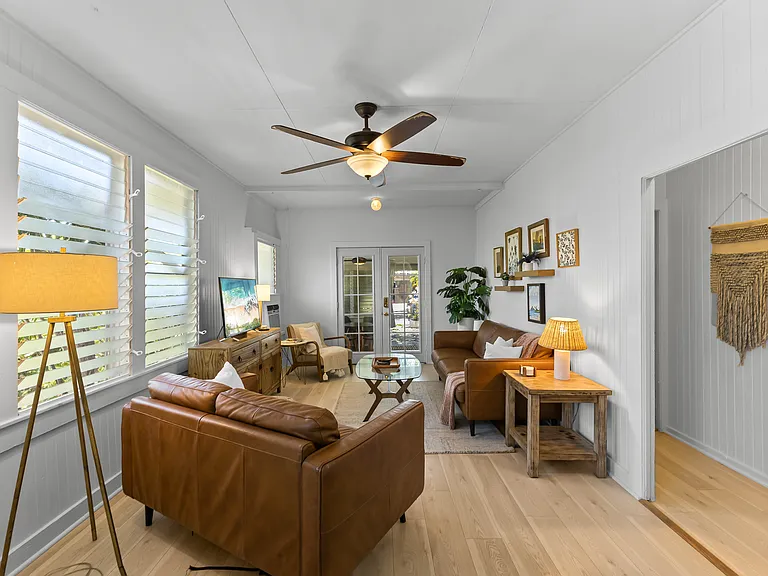 The living room includes an Italian leather sofa and loveseat and one chair, TV, ceiling fan, windows and an AC unit. The living room opens to the lanai and blends seamlessly with the kitchen.