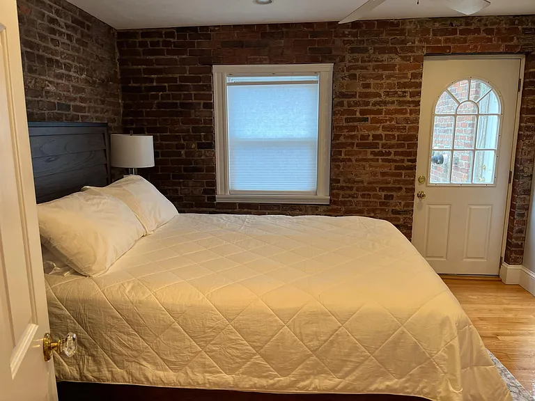 Master bedroom with original exposed brick. Walk out to small private patio. Queen size bed.