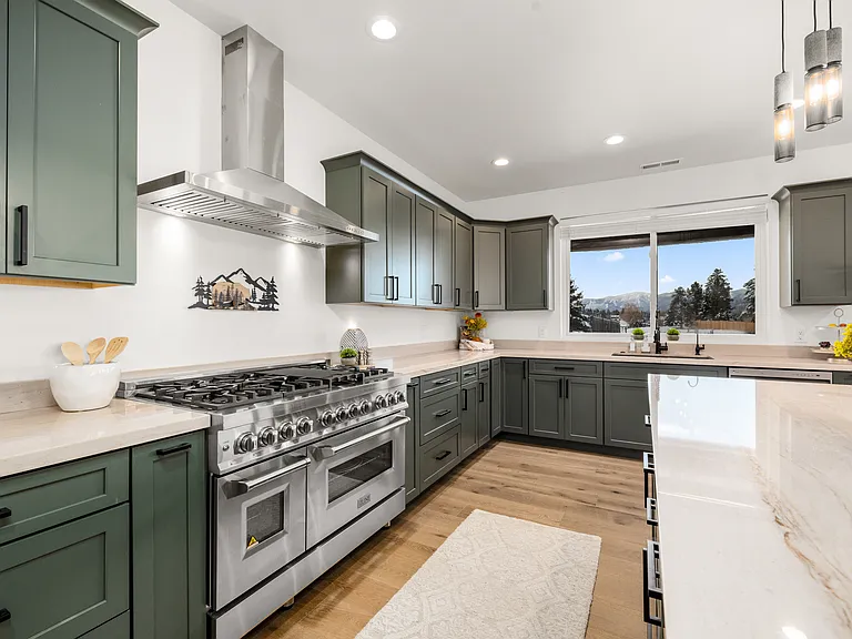 Beautifully designed chef's kitchen featuring a professional-grade range, expansive granite countertops, oversized island, and breathtaking mountain views that bring Montana's natural beauty into the heart of the home.