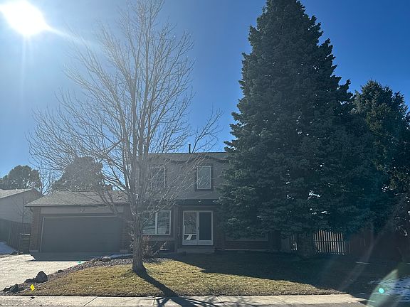 Front of home with professional landscaping and mature trees.