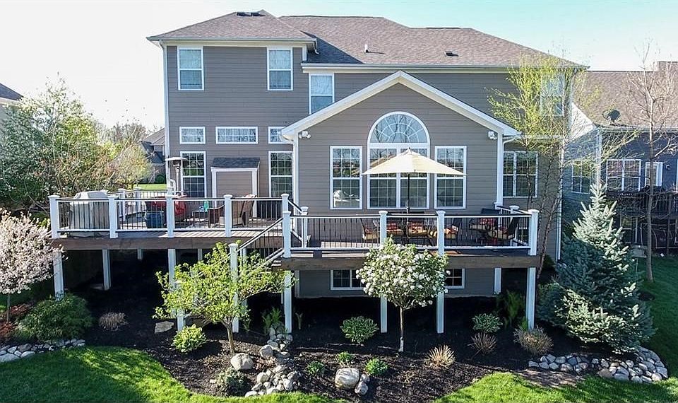 Rear side of home with huge upper deck & gorgeous, professional landscaping