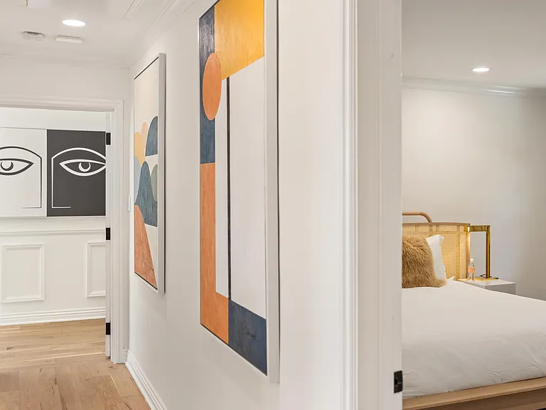 The art-lined hallway guides the way to bedrooms.