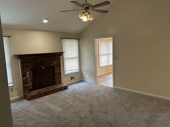 Den with fireplace and vaulted ceiling.
