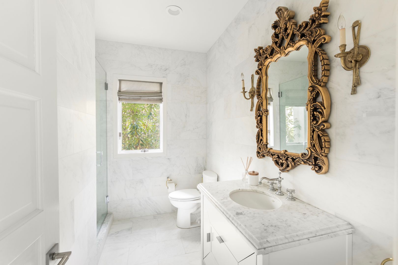  Guest bathroom features marble interiors. Walk-in rain shower and vanity sink.
