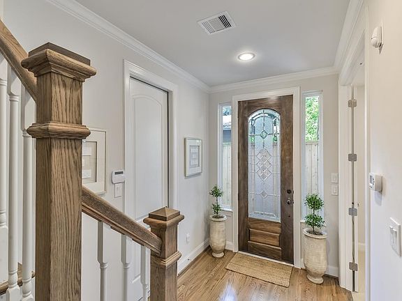The foyer features crown molding and hardwoods. The first floor guest suite has access to patio.