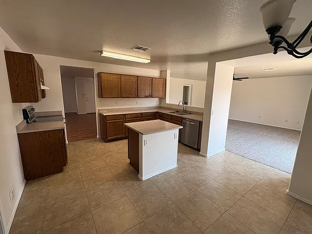 Open concept kitchen with newer stainless steel dishwasher and range