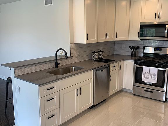 NEW KITCHEN CABINETS WITH QUARTZ COUNTERTOPS AND TILE BACKSPLASH