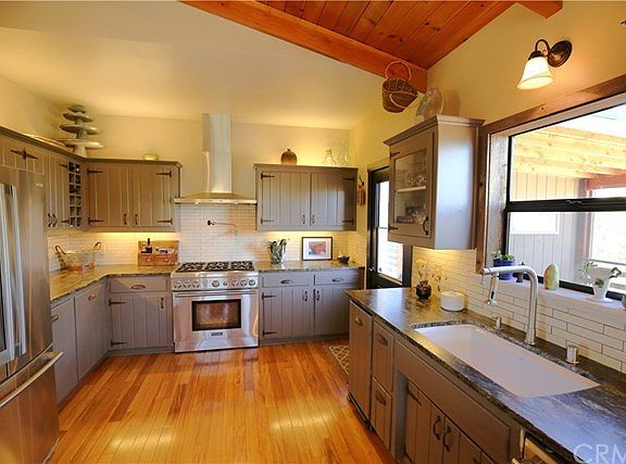 Kitchen has leathered granite counter tops, large sink, 6-burner Thermador range with a pasta faucet above and stainless steel hood.  Lighting both above and below the upper cabinets.