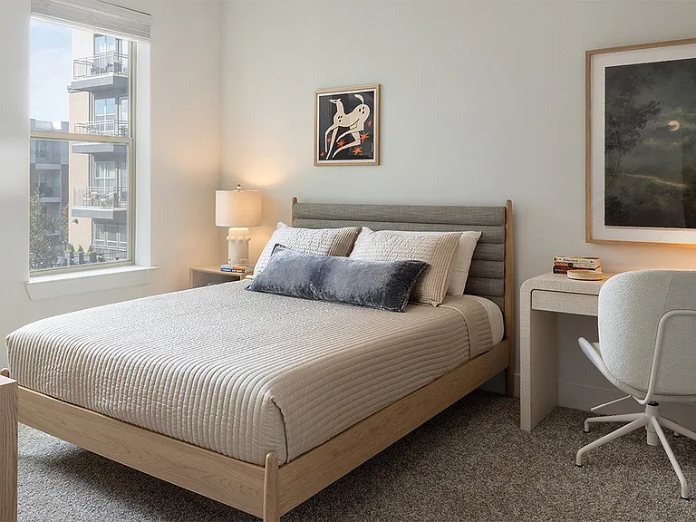 Spacious apartment Bedroom with plush carpet flooring.
