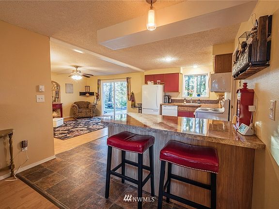 From the family room showing another view of your kitchen with breakfast bar and view of your living room. 