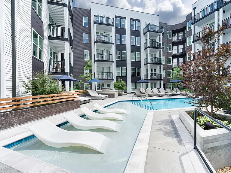 Sun shelf seating and poolside loungers create a refreshing courtyard retreat, with spaces to swim, unwind, and enjoy Atlanta's warm weather.