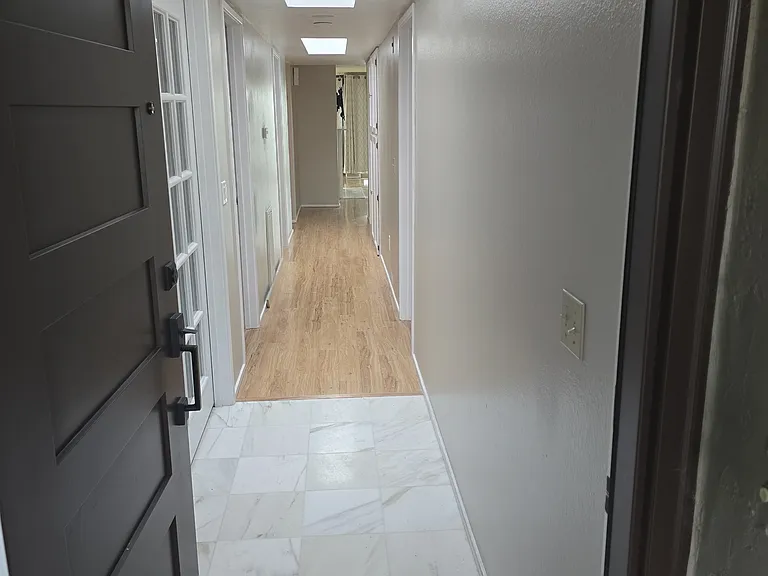 New Front door that opens up to marble floors and hallway with natural lighting