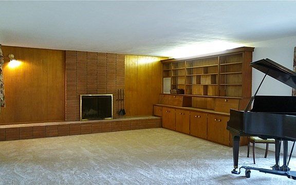 Featuring a very large living room with brick hearth and built in cabinets.
