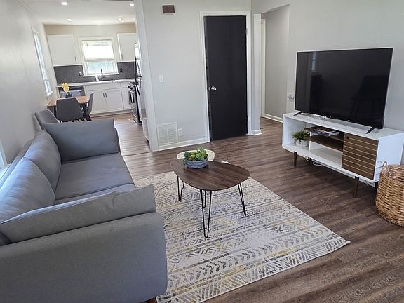 Living room with couch, chair, entertainment center, and TV!