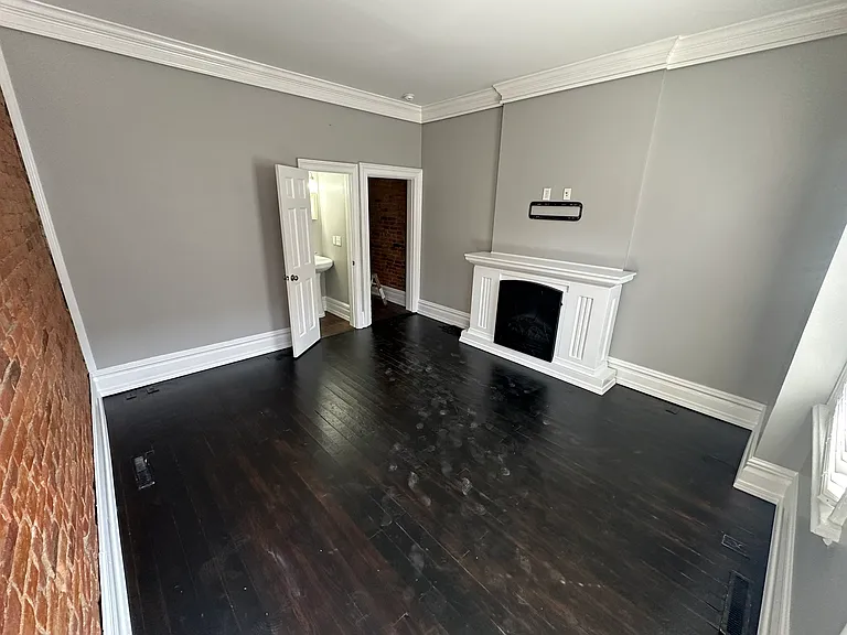 Living Room view from the front door including TV mount and mantle with electric fireplace heater