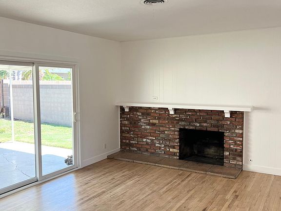 Living room with fireplace and mantle, slider door to covered patio