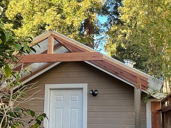 The front entry of the cottage, 7 redwood trees at the neighbor's backyard
