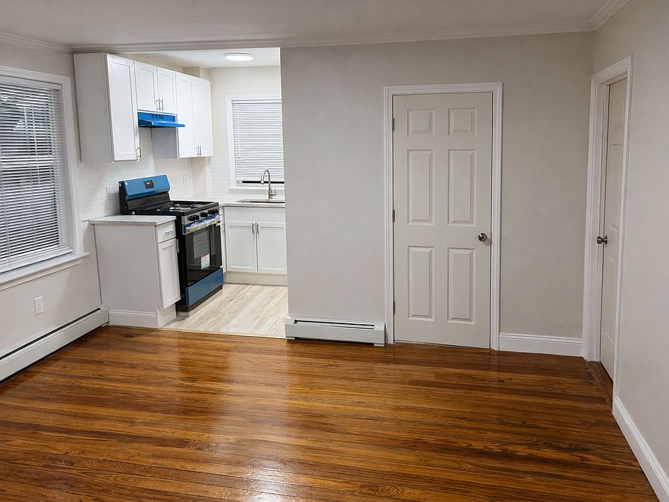 Different view of dining area. Updated kitchen with new cabinets, quartz countertops, stainless steel gas stove (pictured w/ removable blue protective plastic) & doors leading to renovated bathroom & 1/3 bedrooms