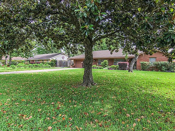 This large yard features beautiful landscaping including two mature magnolia trees.
