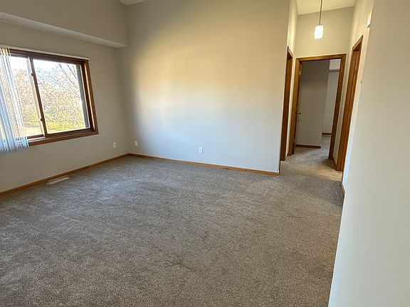 Upper-level living area with neutral flooring and open flow to bedrooms and kitchen.