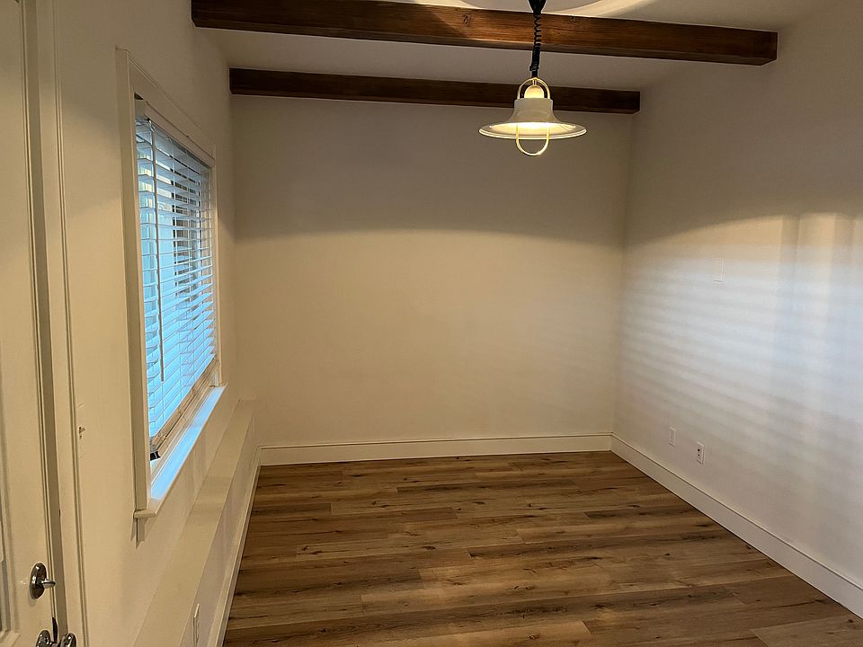 living rm with old wood beams and danish light fixture