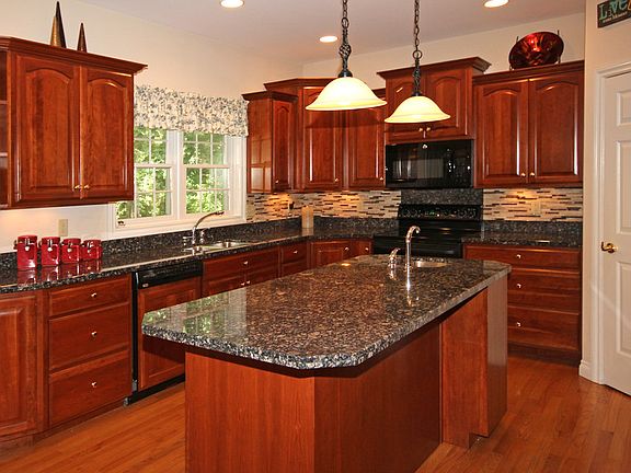KITCHEN FEATURES;Cherry Cabinets, and granite counter tops, and walk in pantry, large eat- in kitchen with French doors leading to a two tiered deck over looking the large wooded back yard.