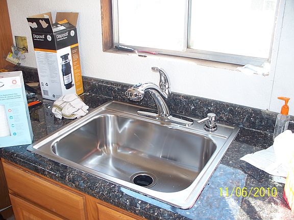 Stainless Steel sink with garbage disposal, faucet is also a sprayer.