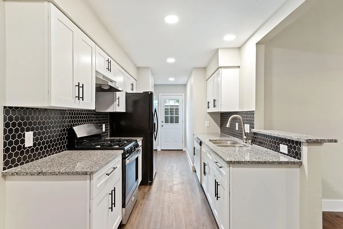 New kitchen with soft-close cabinets, new appliances, pull-down faucet sprayer, and granite countertops. - 604 Peterson St