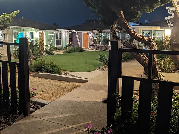 Gated main courtyard with central turf area, fire pit, corn hole court, night time market lights, and plenty of space to relax and chill.